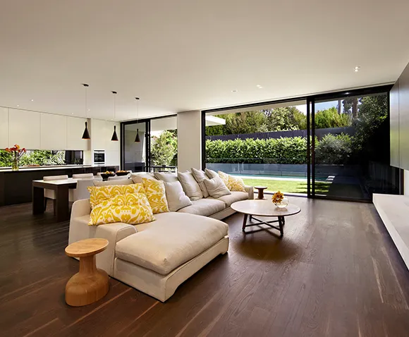 Contemporary living room with floor-to-ceiling windows, highlighting comfortable home interiors.